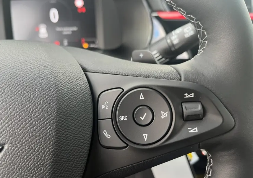 Gros plan sur les commandes du volant à droite de l’Opel Corsa GS Line 2022 noire, avec boutons multifonctions et palettes au volant.