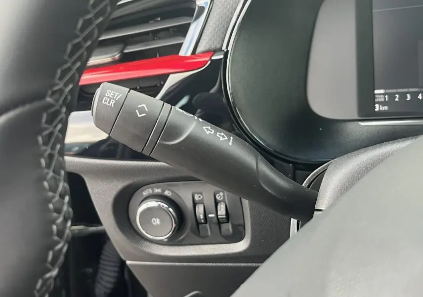 Gros plan sur la commande de clignotant et les réglages d'éclairage du tableau de bord noir de l'Opel Corsa GS Line.