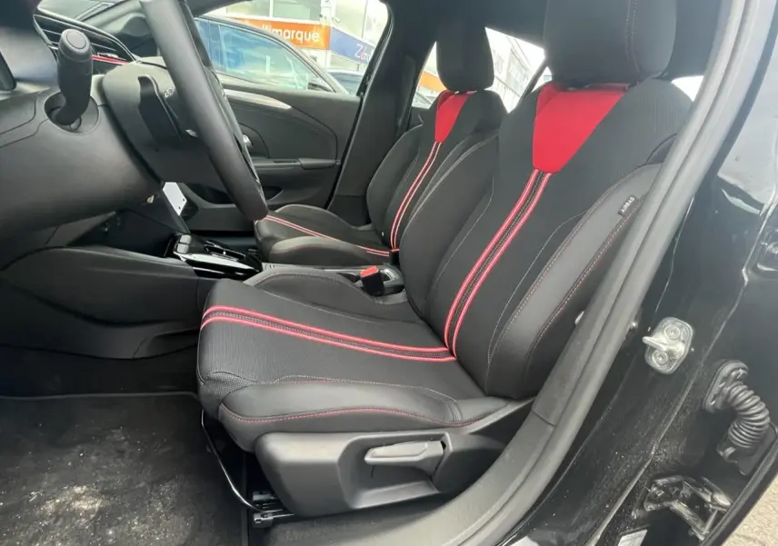 Vue intérieure côté conducteur de l'Opel Corsa GS Line 2022 noire avec sièges sport noirs et rouges.
