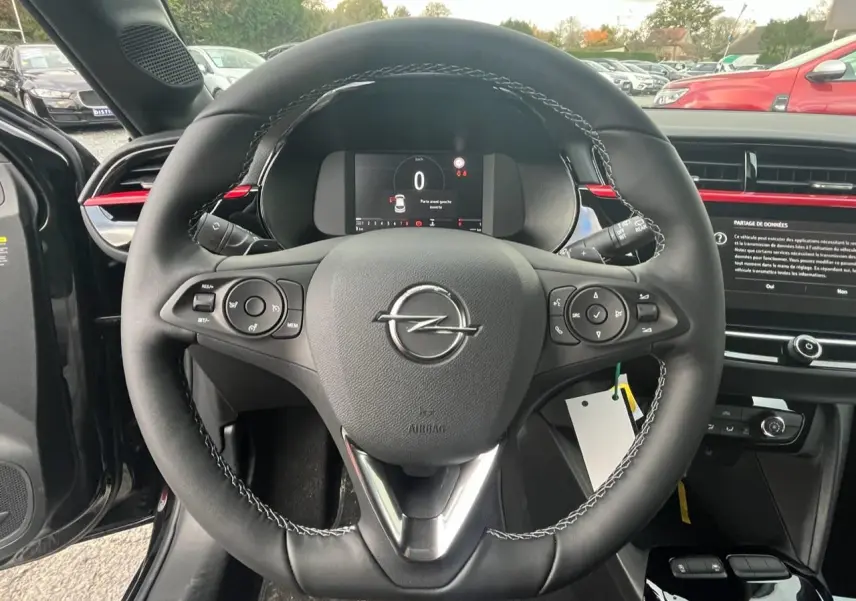 Vue rapprochée du volant cuir noir de l'Opel Corsa GS Line 2022 avec commandes multifonctions et tableau de bord numérique.