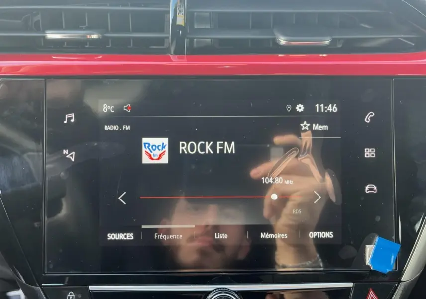 Écran tactile 7 pouces de l'Opel Corsa GS Line 2022 affichant la radio Rock FM en intérieur noir et rouge.
