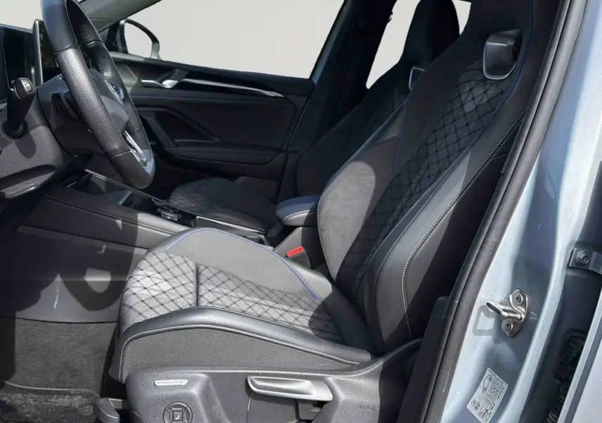 Vue intérieure côté conducteur du Volkswagen Tiguan gris 2025, sièges sport ErgoActive avec surpiqûres et volant cuir multifonction.