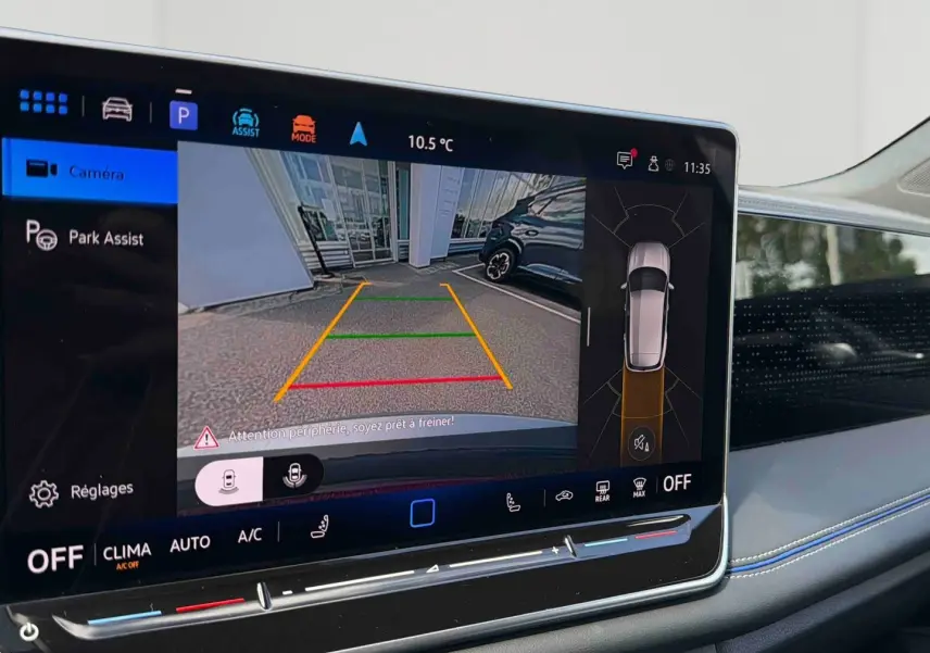 Écran tactile intérieur du Volkswagen Tiguan 2025 montrant l'assistance au stationnement en caméra de recul.