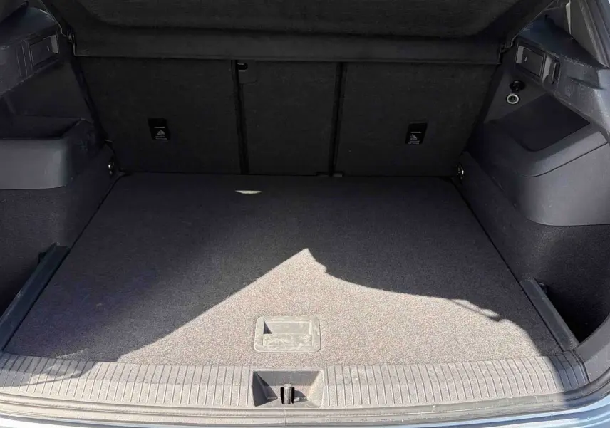 Coffre ouvert du Volkswagen Tiguan gris 2025, montrant un espace de chargement propre et bien agencé.