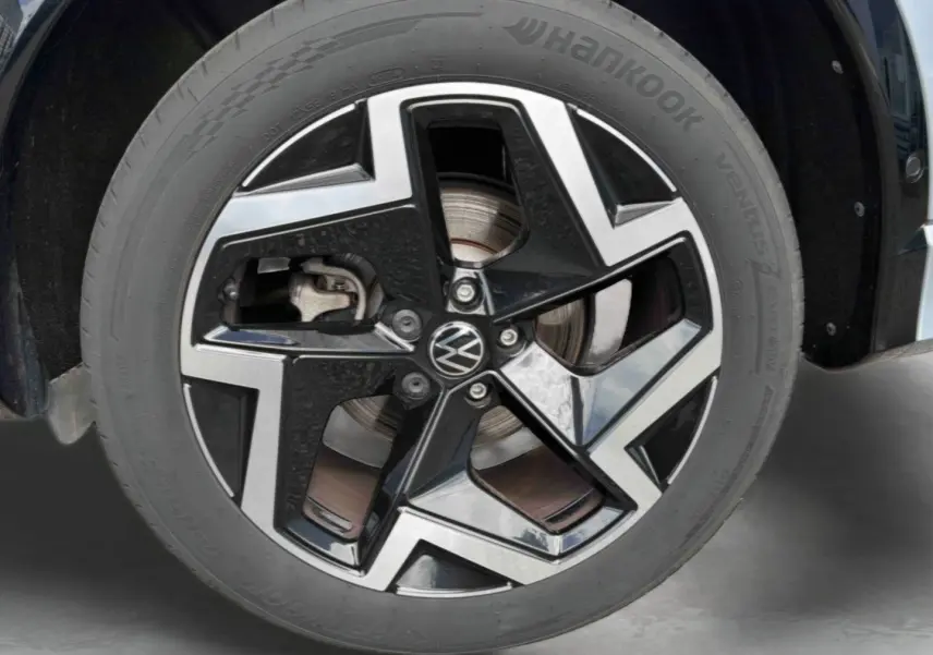 Gros plan sur la jante en alliage noir et brillant de 19 pouces du Volkswagen Tiguan gris, avec logo VW central.