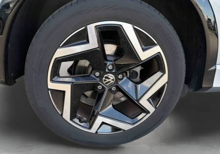 Gros plan sur la jante alliage Coventry noire et brillante du côté avant droit du Volkswagen Tiguan gris 2025.