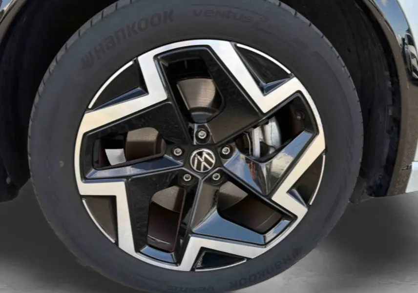 Gros plan sur la jante en alliage noir et brillant Coventry 19 pouces du Volkswagen Tiguan gris 2025.