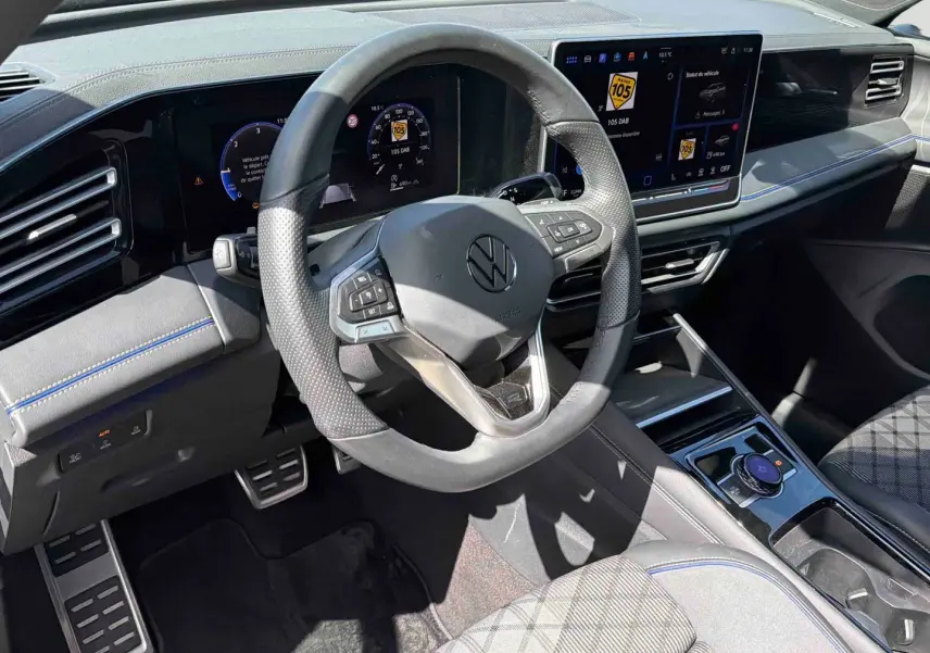Vue intérieure côté conducteur du Volkswagen Tiguan 2025, volant cuir multifonction et écran tactile digital.