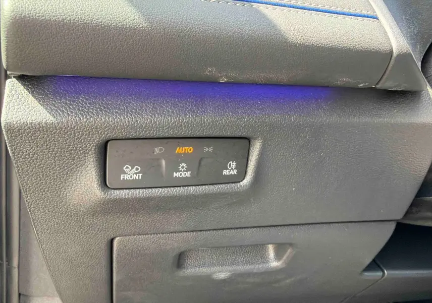 Détail des commandes d’éclairage sur le côté gauche du tableau de bord d’un Volkswagen Tiguan gris.