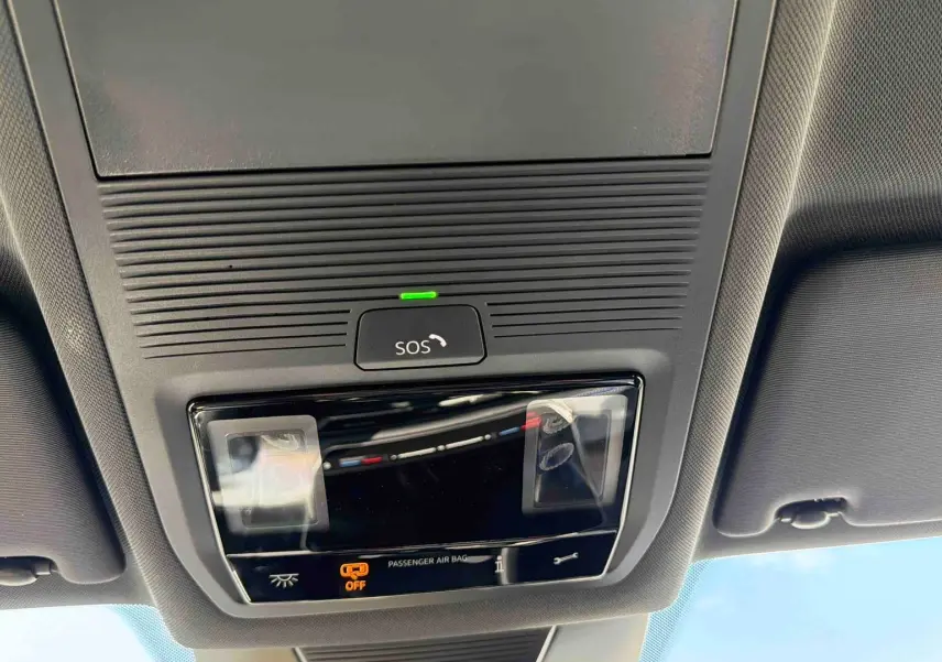 Plafonnier intérieur avec bouton SOS et éclairage, vue du toit d’un Volkswagen Tiguan gris 2025.