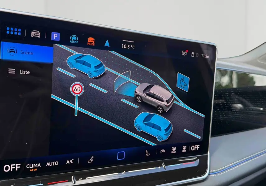 Écran tactile intérieur du Volkswagen Tiguan 2025 montrant l'assistance au maintien de voie et la détection des véhicules alentours.