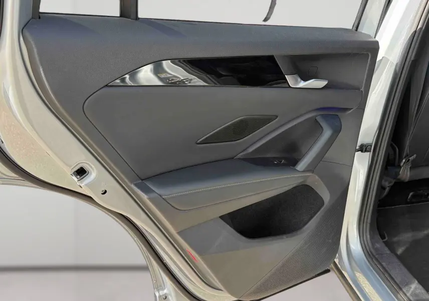 Vue rapprochée de la porte arrière droite grise du Volkswagen Tiguan 2025, avec garniture noire et poignée argentée.