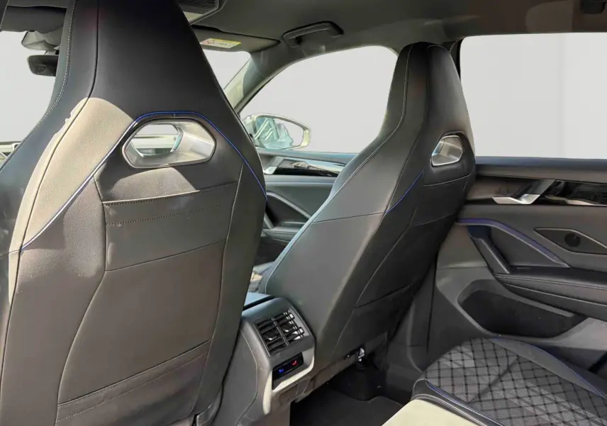 Vue arrière intérieure des sièges avant en cuir noir avec surpiqûres bleues du Volkswagen Tiguan 2025.