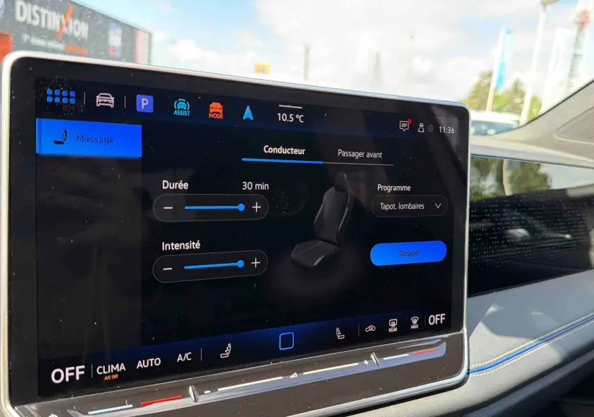 Écran tactile central du Volkswagen Tiguan 2025 montrant le réglage du massage siège côté passager, intérieur clair avec surpiqûres bleues.