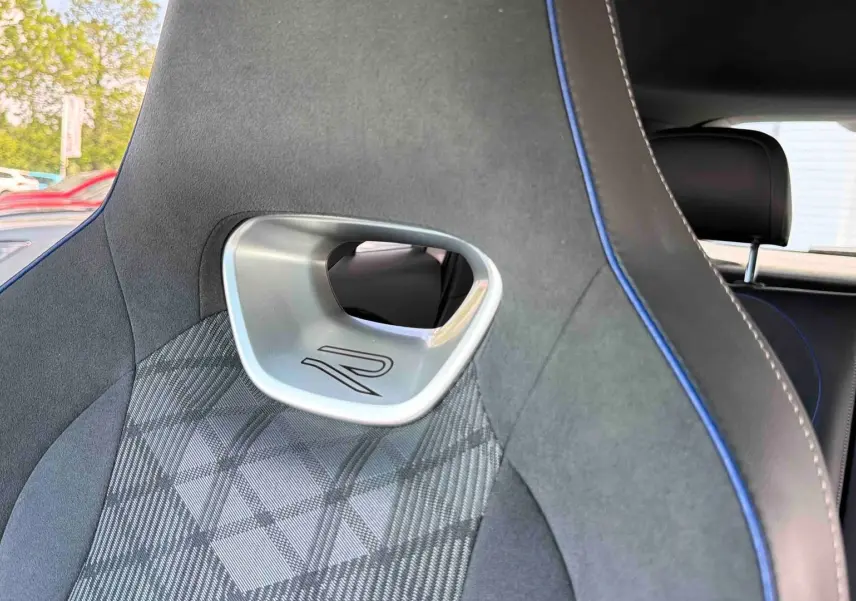 Détail du siège avant gris avec surpiqûres bleues et logo R, intérieur du Volkswagen Tiguan 2025.
