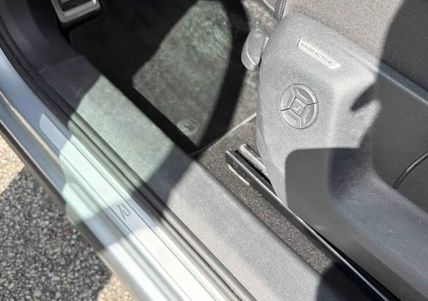 Détail de la porte côté conducteur du Volkswagen Tiguan gris 2025 avec siège ErgoActive et seuil de porte marqué R.