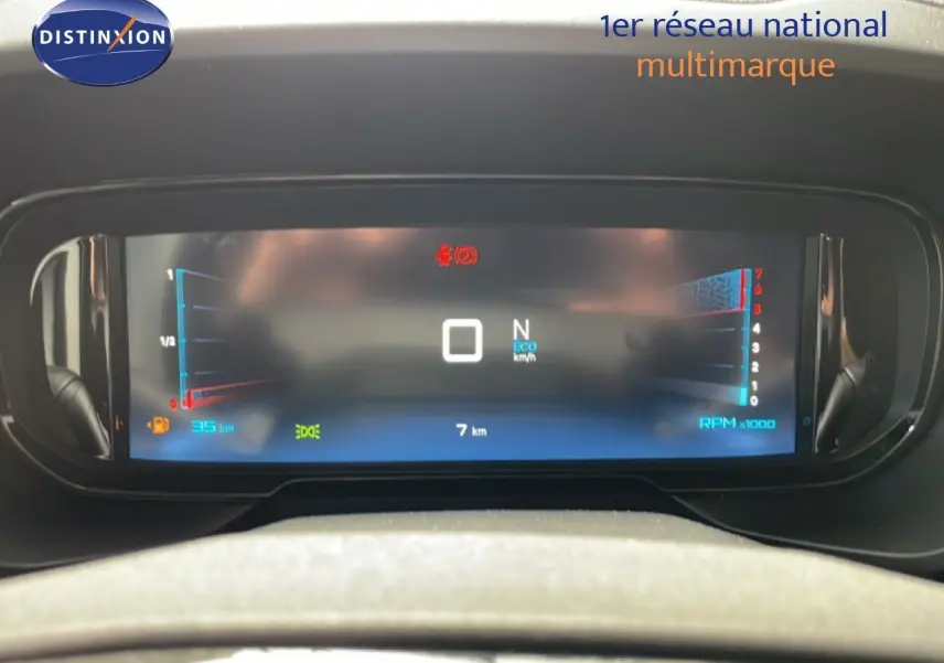 Tableau de bord numérique du Citroën Berlingo gris, affichant vitesse, RPM et indicateurs, vue frontale rapprochée.
