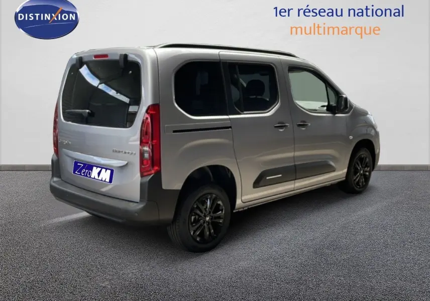 Vue 3/4 arrière droite d'un Citroën Berlingo gris Artense métal avec vitres teintées et jantes noires.