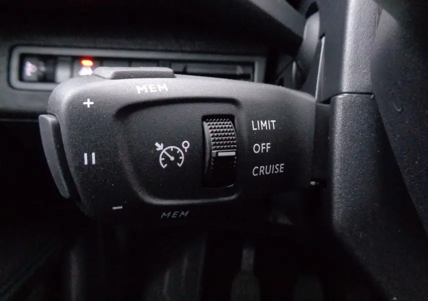 Gros plan sur la commande de régulateur de vitesse du Peugeot 3008 2023, finition gris intérieur.