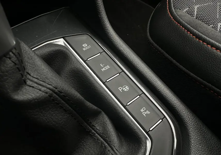 Gros plan sur la console centrale noire avec commandes de modes de conduite et siège sport noir avec surpiqûres rouges du SEAT Tarraco.
