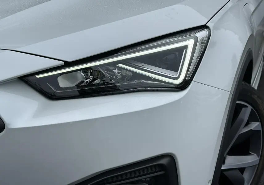 Gros plan sur le phare avant droit blanc Oryx du SEAT Tarraco 1.4 e-Hybrid 2024 avec jante alliage 20 pouces.