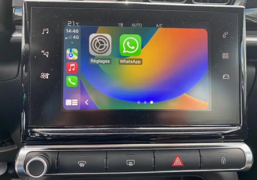 Écran tactile central de la Citroën C3 2017 affichant Apple CarPlay avec applications Réglages et WhatsApp, vue frontale rapprochée.