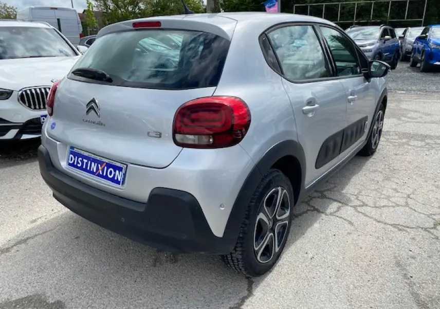 Vue 3/4 arrière droite d'une Citroën C3 gris clair avec protections latérales noires et jantes 16 pouces.