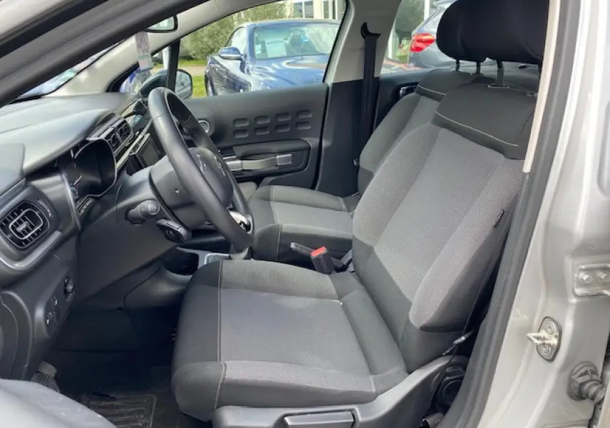 Vue intérieure côté conducteur de la Citroën C3 gris clair 2017 avec sièges en tissu Mica Grey et tableau de bord moderne.