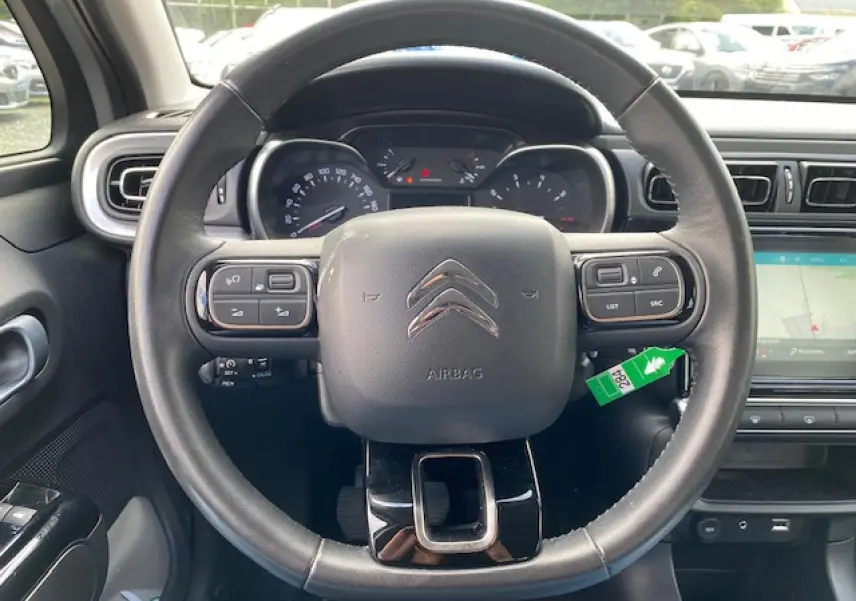 Vue frontale du volant noir de la Citroën C3 2017 avec tableau de bord et écran tactile GPS visible à droite.
