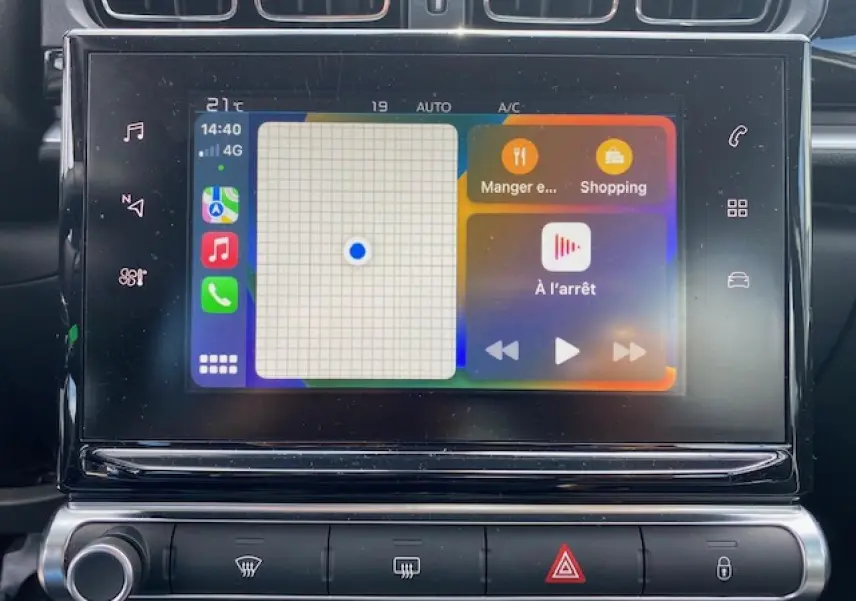 Écran tactile central de la Citroën C3 gris clair 2017 affichant Apple CarPlay avec navigation et musique à l'arrêt.