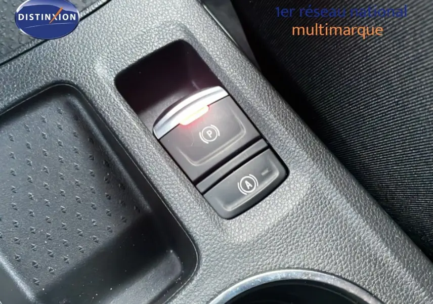 Gros plan sur la console centrale de la Renault Symbioz gris cassiopée, montrant les boutons de frein à main électrique et auto hold.