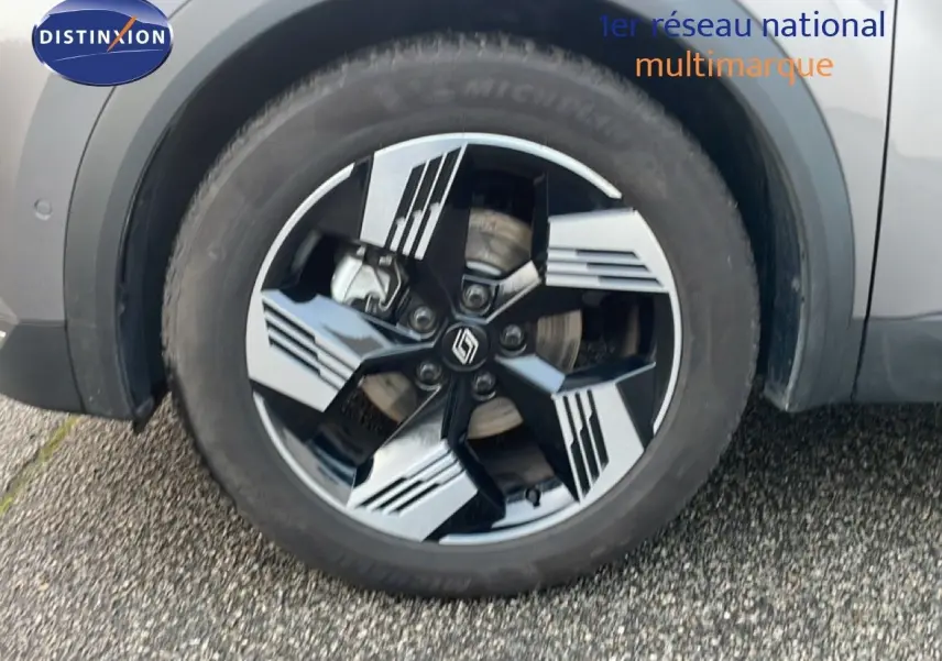 Gros plan sur la roue avant gauche du Renault Symbioz gris cassiopée métal, avec jante noire et argentée au design moderne.