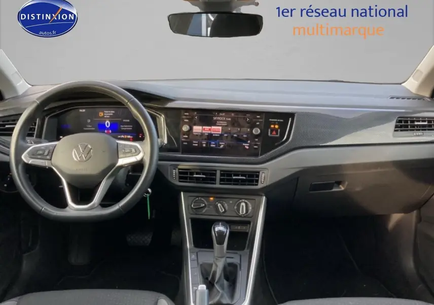 Vue intérieure avant du tableau de bord gris et noir de la Volkswagen Polo 1.0 TSI 95 VW Edition avec écran tactile et volant cuir.