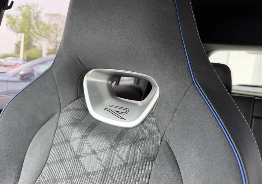 Gros plan sur le siège avant sport gris avec surpiqûres bleues et logo R du Volkswagen Tiguan 2025.