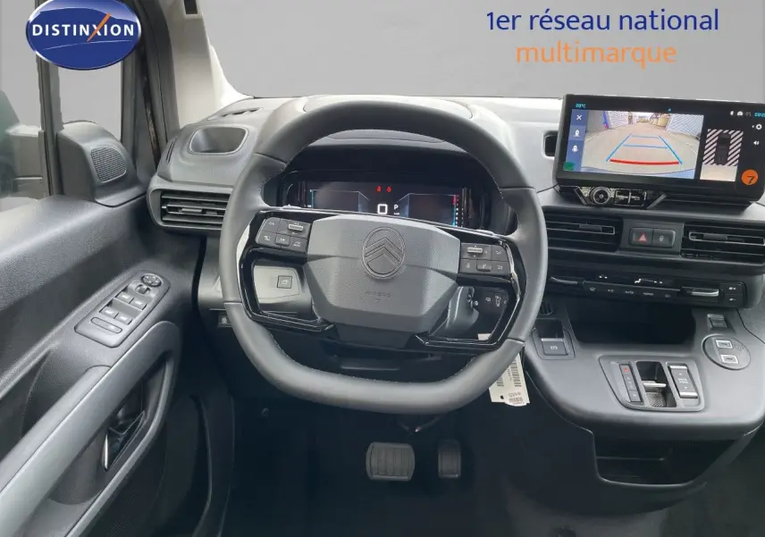 Vue intérieure frontale du tableau de bord du Citroën Berlingo 2026, volant multifonction et écran de caméra de recul.