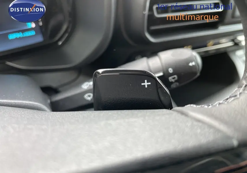 Gros plan sur la palette de changement de vitesse droite du volant d’un Citroën Berlingo noir Perla Nera, intérieur sombre.