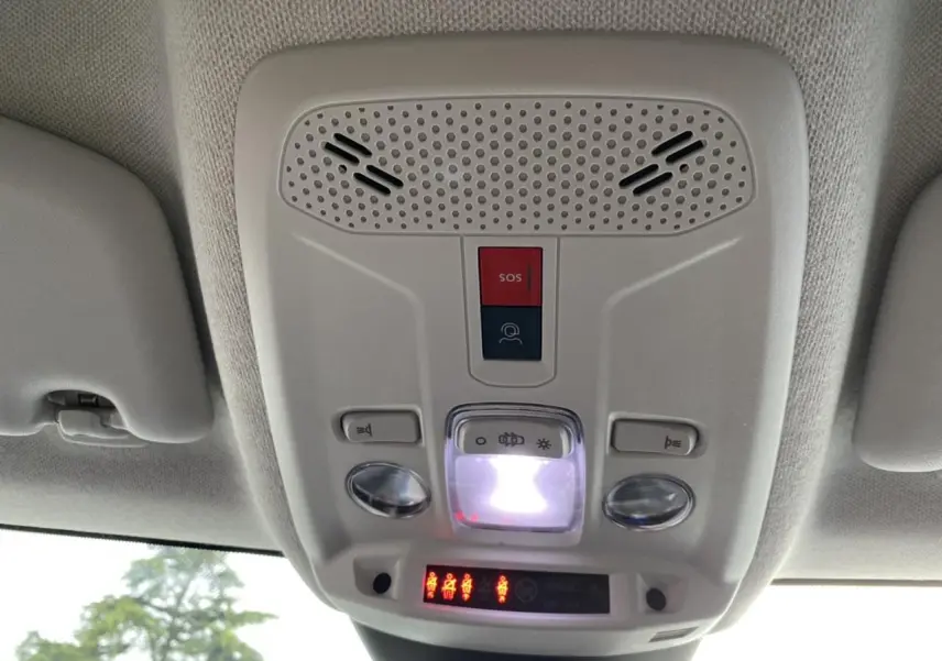 Vue du plafonnier intérieur gris clair du Citroën C4 2021 avec boutons SOS et éclairage central allumé.