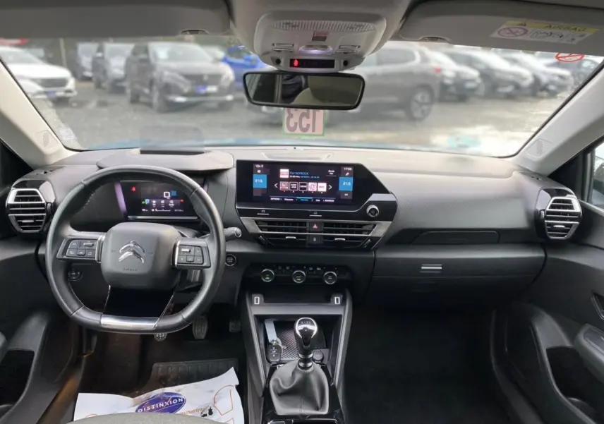 Vue intérieure avant du tableau de bord et volant d'une Citroën C4 2021 avec boîte manuelle et écran tactile central.