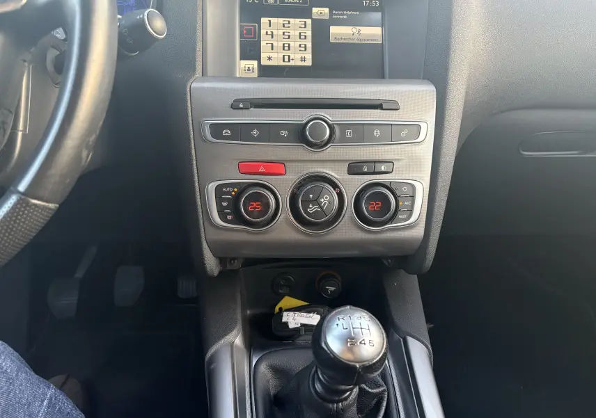 Vue intérieure centrée sur la console centrale d'une Citroën C4 II 2.0 HDI 150 HYB 2015 avec boîte manuelle et climatisation digitale.