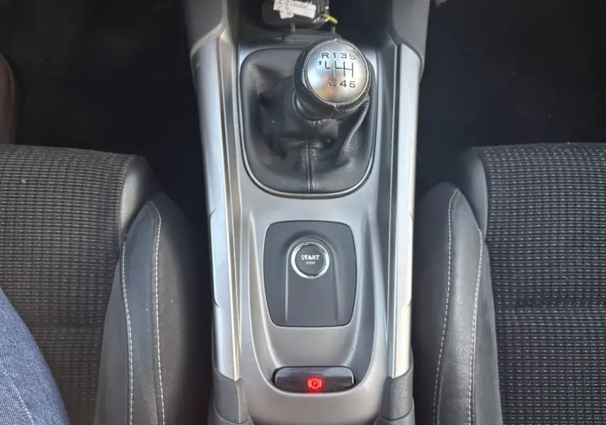 Vue plongeante sur la console centrale d'une Citroën C4 II 2.0 HDI 150 HYB 2015 avec levier de vitesse manuel et bouton start/stop.