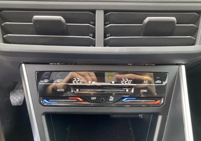 Détail de la console centrale du Volkswagen Taigo 2022 montrant la climatisation automatique bi-zone à 22°C.