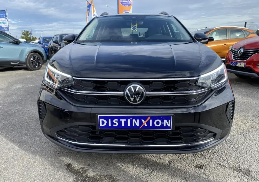 Vue frontale d'un Volkswagen Taigo noir intense 2022 avec calandre hexagonale et logo VW central visible.