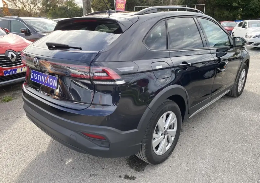 Volkswagen Taigo noir intense vu en 3/4 arrière droit, avec feux arrière allongés et toit ouvrant panoramique.