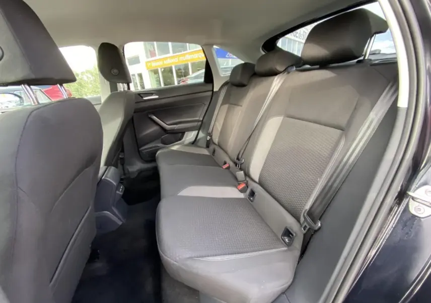 Vue intérieure côté droit des sièges arrière noirs du Volkswagen Taigo 2022 avec porte ouverte et ceinture de sécurité visible.