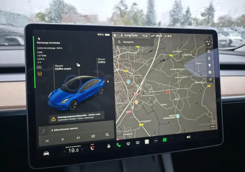 Écran tactile intérieur montrant la Tesla Model 3 RWD bleu foncé avec carte de navigation et statut de recharge.