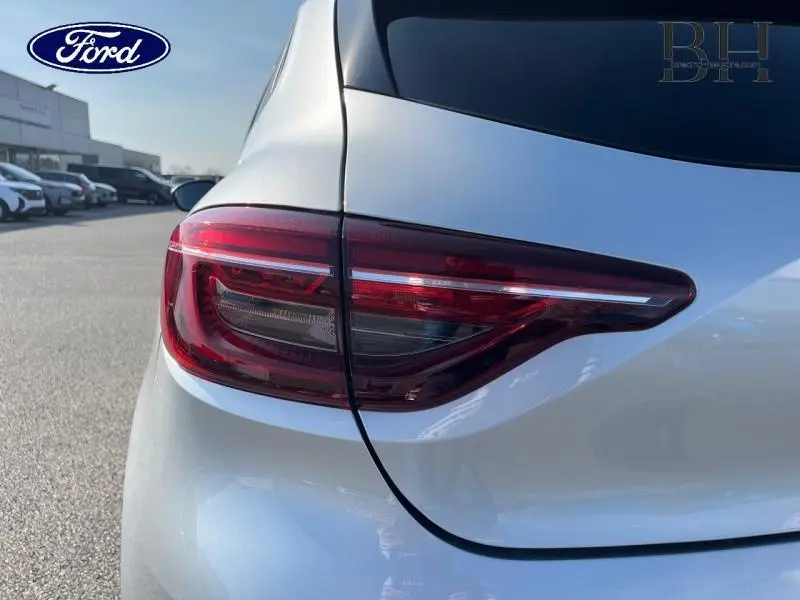 Gros plan sur le feu arrière droit d'une Renault Clio gris platine, soulignant la forme moderne et les lignes épurées.