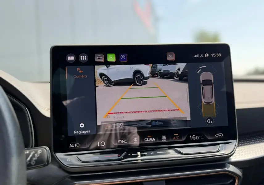 Écran tactile intérieur montrant la caméra de recul avec vue arrière d’un CUPRA Formentor blanc Neige.
