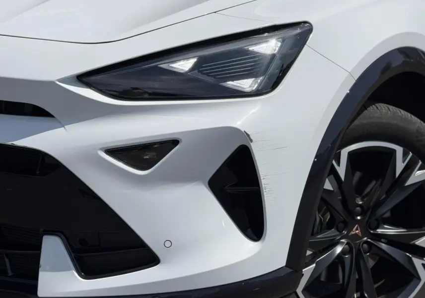 Gros plan sur l'avant droit blanc neige du CUPRA Formentor 2025 avec projecteur Tri-LED et jante alliage noire.