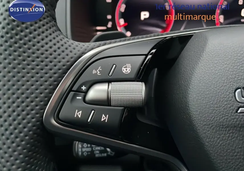 Gros plan sur les commandes au volant côté gauche du Skoda Karoq gris argent 2025, avec molette et boutons multifonctions.