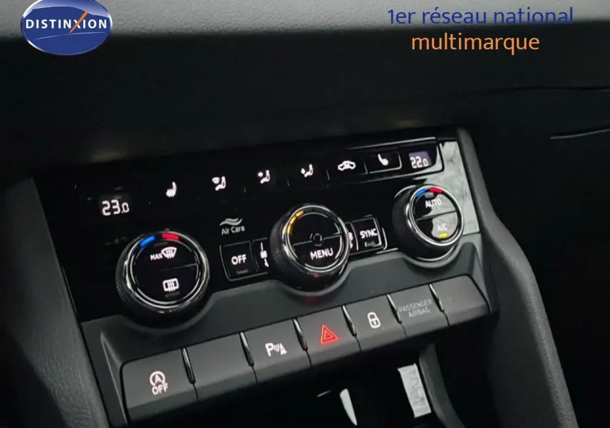 Vue rapprochée de la console centrale du Skoda Karoq gris argent 2025, montrant les commandes de climatisation et les boutons de sécurité.